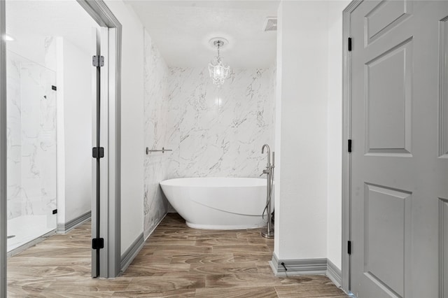 bathroom with wood-type flooring, separate shower and tub, and tile walls