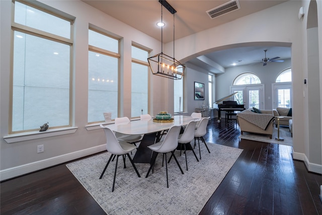 dining room with dark hardwood / wood-style floors and ceiling fan with notable chandelier