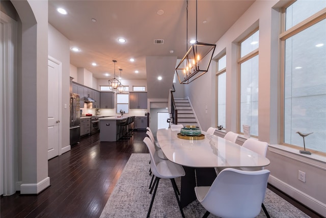 dining space featuring dark wood-type flooring, sink, and a notable chandelier