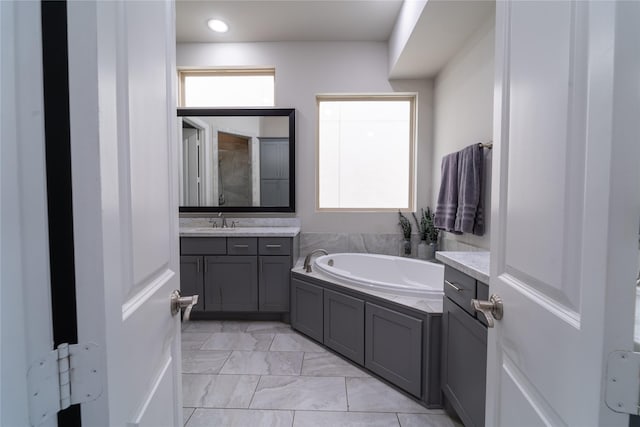 bathroom with vanity and a bath