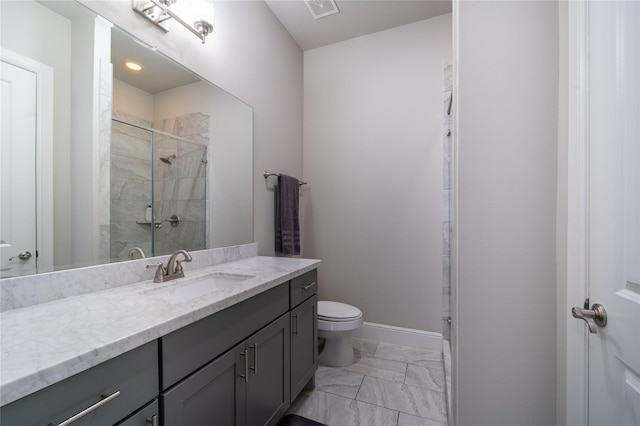 bathroom with vanity, a shower with door, and toilet