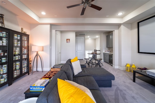 living room featuring light colored carpet, wine cooler, ceiling fan, and bar area