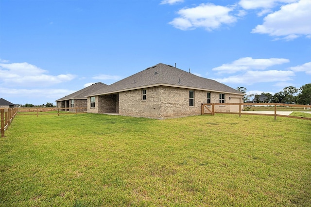 back of property featuring a lawn, driveway, a fenced backyard, a garage, and brick siding