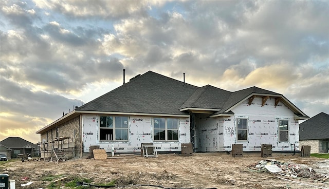 back of property with roof with shingles