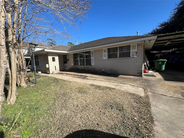 ranch-style home featuring a front yard and a carport