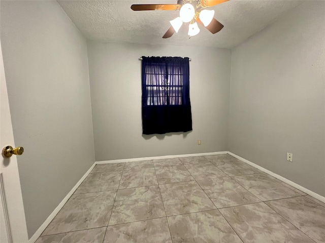 tiled empty room featuring ceiling fan and a textured ceiling