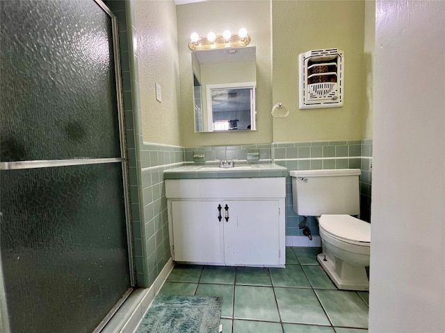 bathroom with walk in shower, toilet, tile walls, vanity, and tile patterned flooring