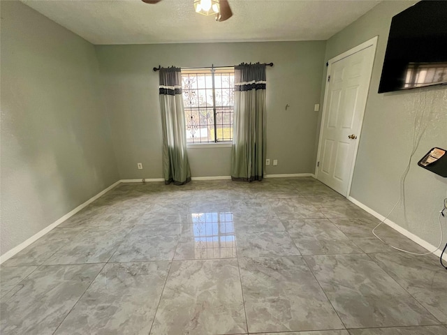 spare room featuring a textured ceiling and ceiling fan