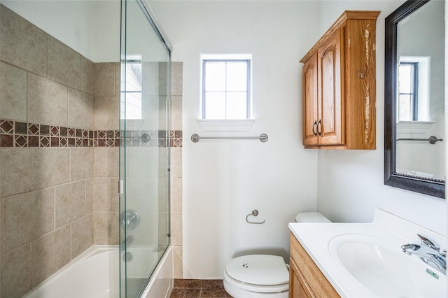 full bathroom featuring enclosed tub / shower combo, vanity, and toilet