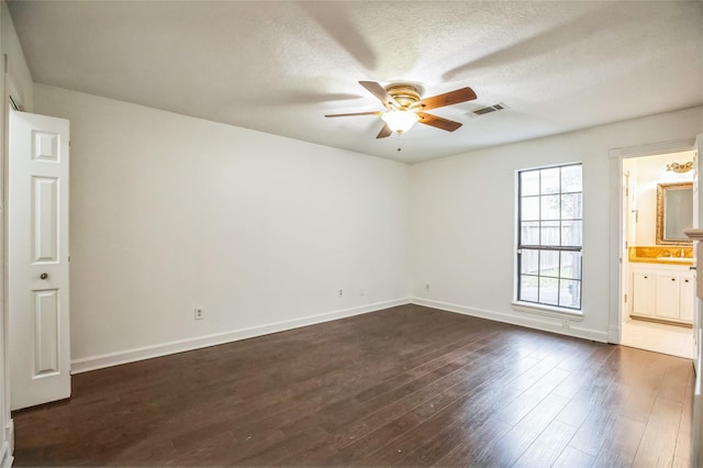 unfurnished room featuring ceiling fan, dark wood-type flooring, sink, and a textured ceiling