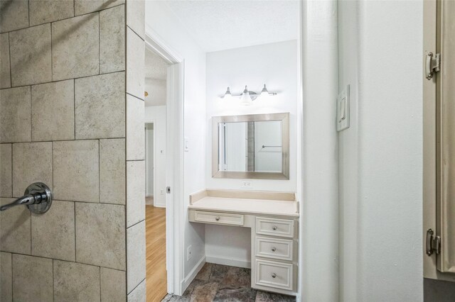 bathroom featuring vanity, a textured ceiling, and walk in shower