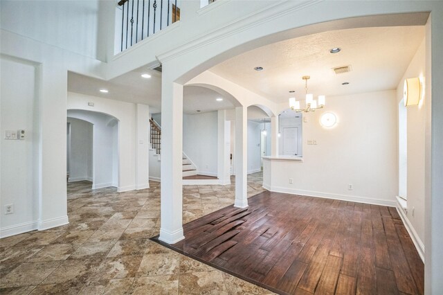 interior space featuring a towering ceiling, hardwood / wood-style floors, and an inviting chandelier