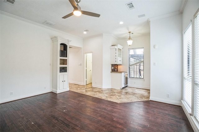 unfurnished living room featuring crown molding, plenty of natural light, and light wood-type flooring