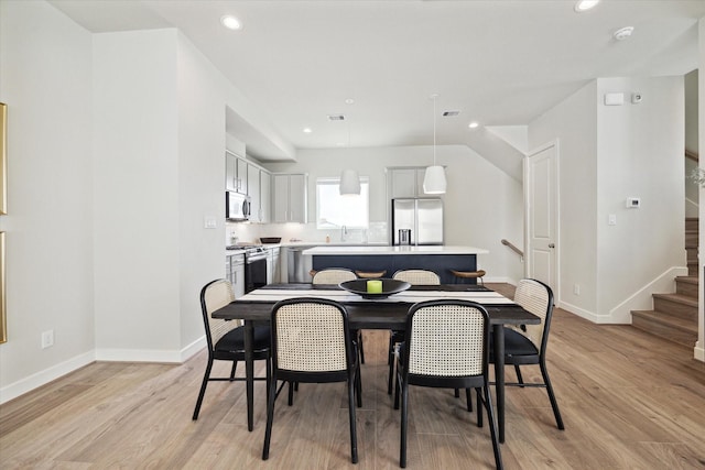 dining space featuring sink and light wood-type flooring