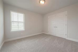 4310 Karam Lndg, Dickinson, TX 77539 - unfurnished bedroom with carpet flooring, a closet, and baseboards