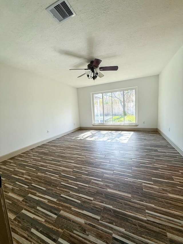 spare room with dark hardwood / wood-style flooring, ceiling fan, and a textured ceiling