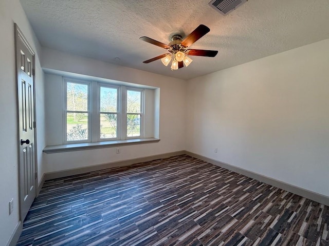 spare room featuring ceiling fan, a textured ceiling, and dark hardwood / wood-style flooring