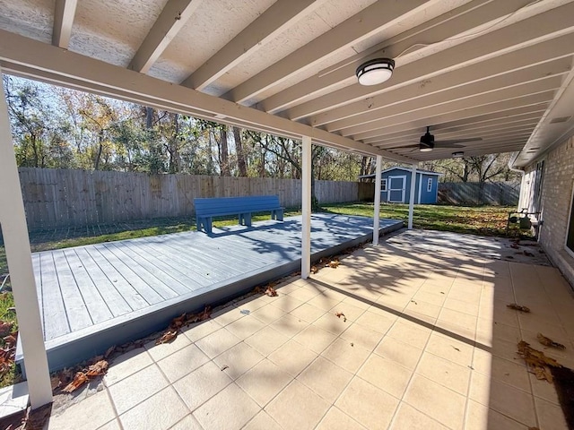 wooden terrace with a patio and a storage unit