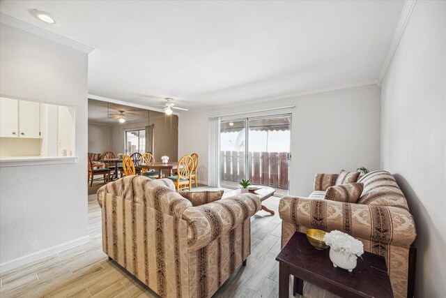 living room featuring crown molding, ceiling fan, and light wood-type flooring