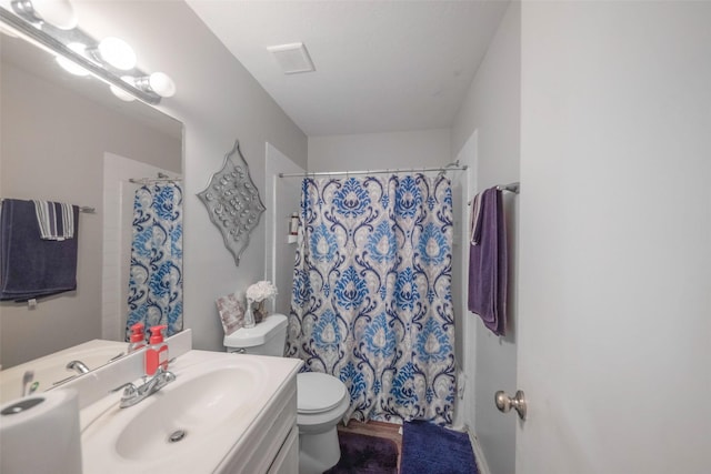 bathroom with vanity, curtained shower, and toilet