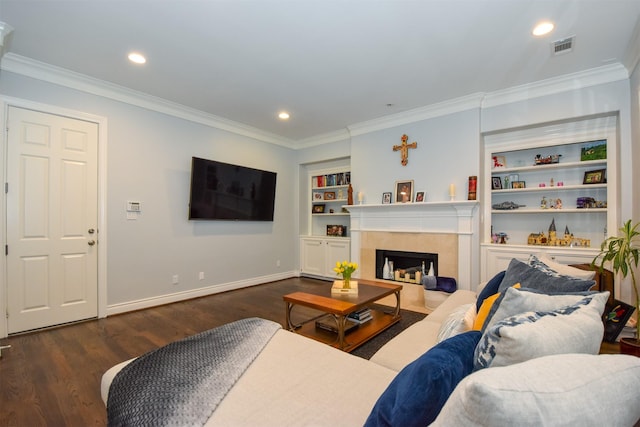 living room with a fireplace, built in features, dark wood-type flooring, and ornamental molding