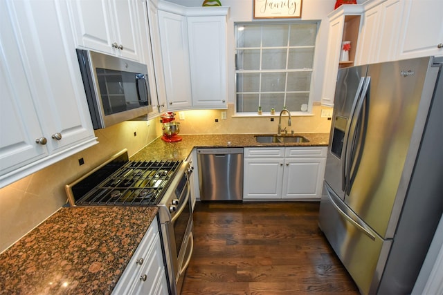 kitchen with sink, white cabinetry, dark stone counters, dark hardwood / wood-style flooring, and stainless steel appliances