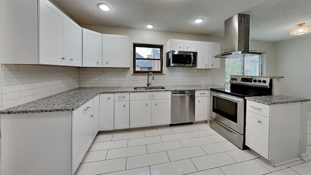 kitchen with island range hood, stainless steel appliances, and white cabinets