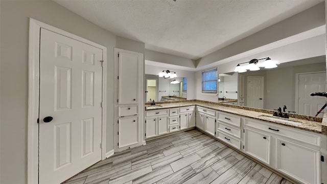 bathroom with vanity and a textured ceiling