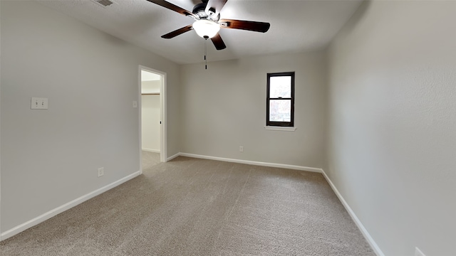 spare room featuring ceiling fan and light colored carpet