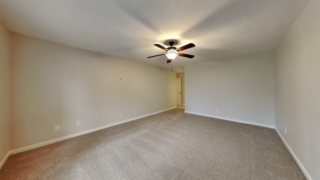 spare room featuring ceiling fan, carpet, and a textured ceiling