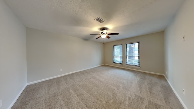 carpeted spare room with ceiling fan and a textured ceiling