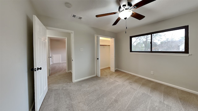 unfurnished bedroom featuring light carpet, ceiling fan, and a closet