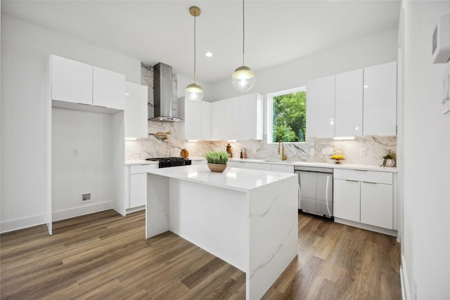 kitchen with white cabinetry, decorative light fixtures, dishwasher, and wall chimney range hood