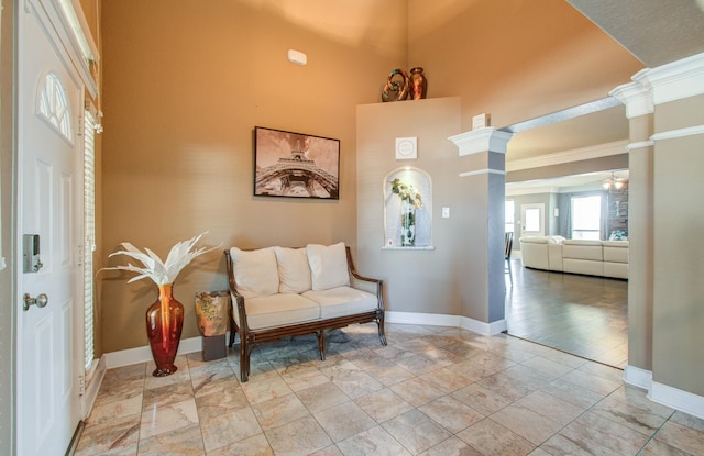 living area with decorative columns and a towering ceiling