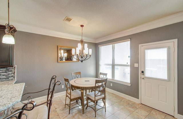 dining space featuring ornamental molding and a notable chandelier