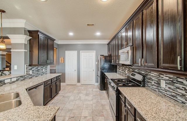 kitchen with light stone counters, decorative light fixtures, dark brown cabinets, and stainless steel appliances