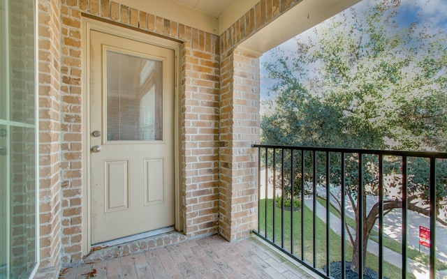 view of exterior entry featuring a balcony