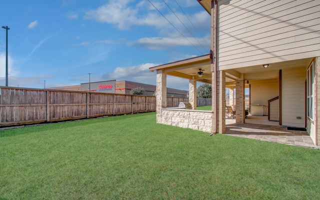 view of yard with ceiling fan and a patio area