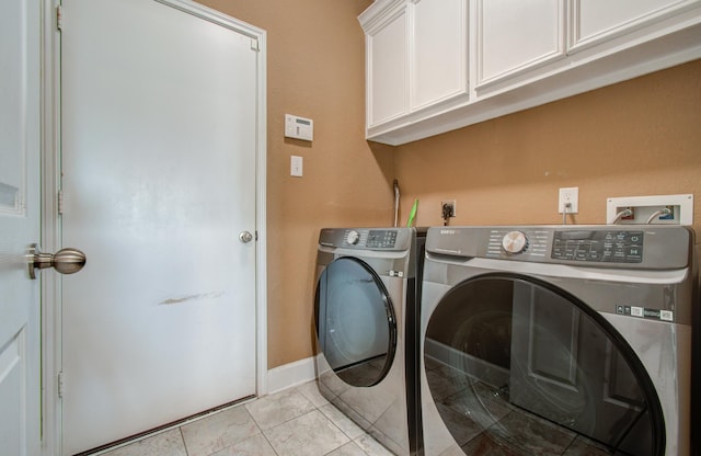 washroom featuring cabinets, washer and dryer, and light tile patterned floors