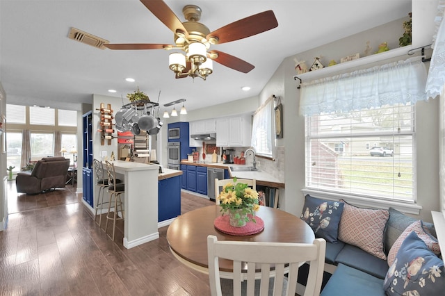 dining space featuring dark hardwood / wood-style flooring, sink, plenty of natural light, and ceiling fan