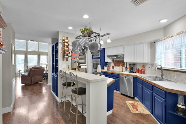 kitchen featuring blue cabinets, white cabinetry, sink, stainless steel dishwasher, and black electric cooktop