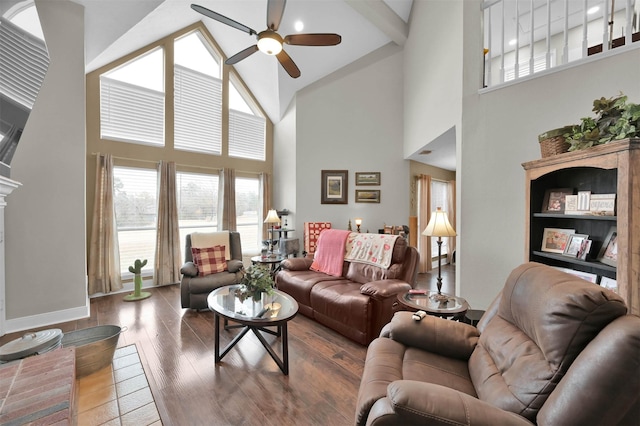 living room with wood-type flooring, a towering ceiling, and ceiling fan