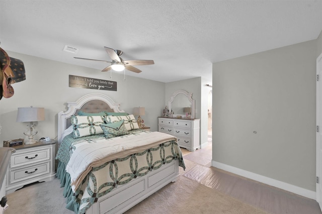 bedroom featuring ceiling fan and a textured ceiling