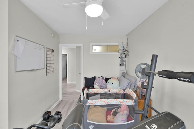 workout area featuring ceiling fan and light wood-type flooring