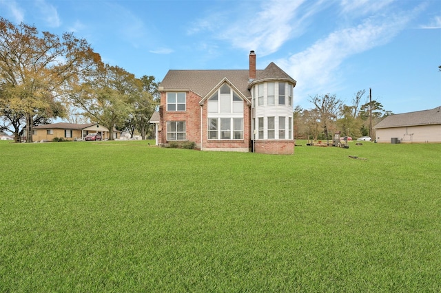 rear view of house featuring a yard