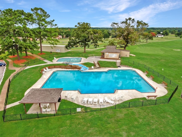 view of pool with an outbuilding, a yard, and a patio