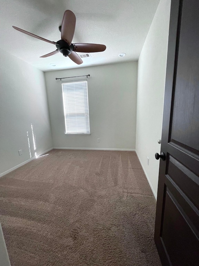 spare room with carpet floors and ceiling fan