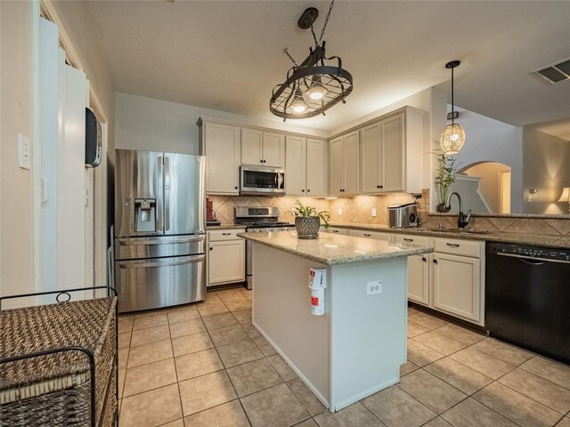 kitchen with a kitchen island, appliances with stainless steel finishes, pendant lighting, sink, and light tile patterned floors