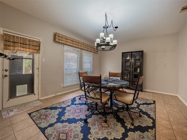 tiled dining room featuring a notable chandelier