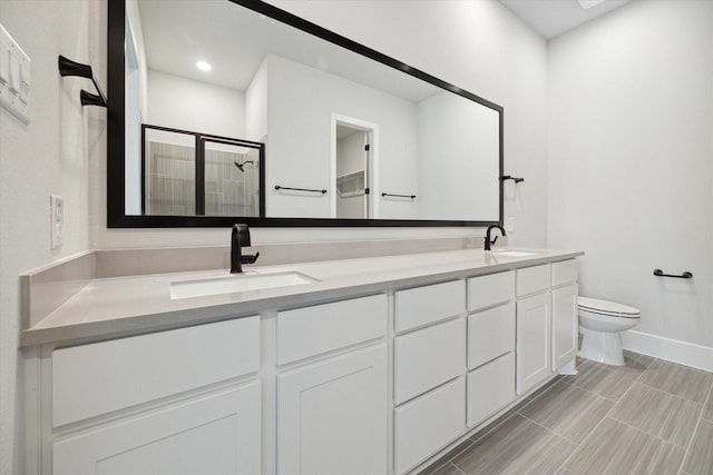 bathroom featuring vanity, an enclosed shower, and toilet